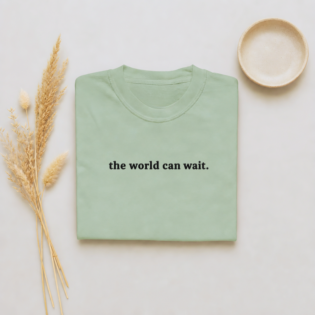 Bay garment-dyed Comfort Colors tee with "the world can wait" embroidered on the chest, Soft Rebellion