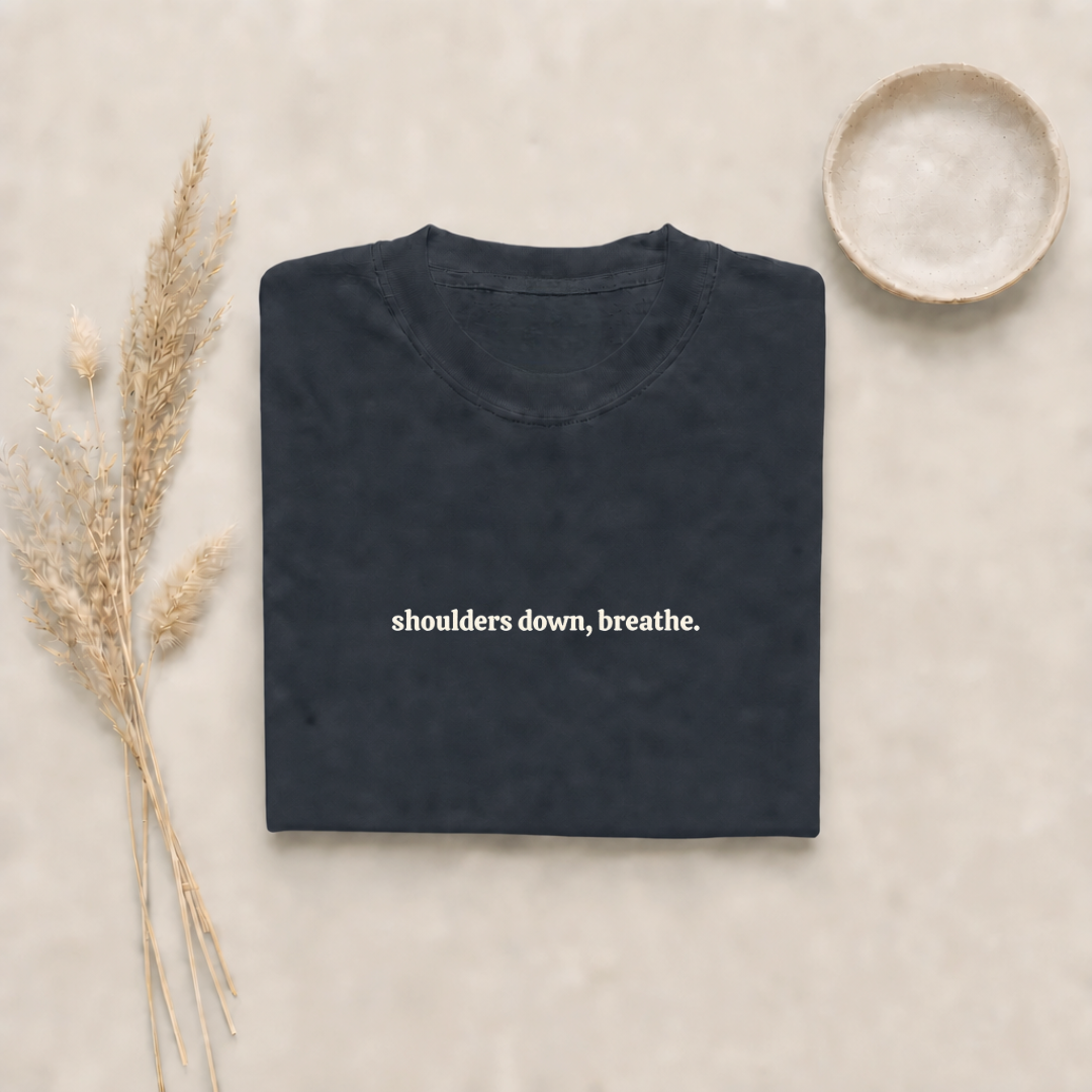 Graphite garment-dyed Comfort Colors tee with "shoulders down, breathe" embroidered on the chest, Soft Rebellion