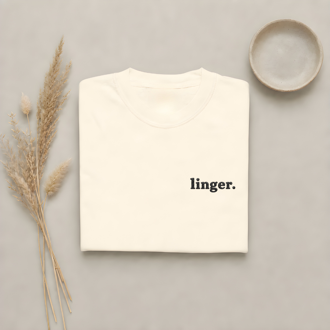 Ivory garment-dyed Comfort Colors tee with "linger" embroidered on the chest, Soft Rebellion
