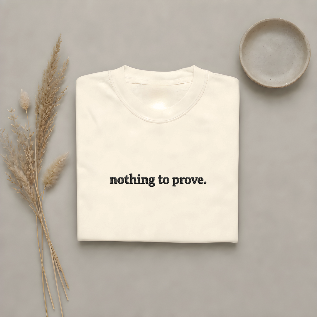 Ivory garment-dyed Comfort Colors tee with "nothing to prove" embroidered on the chest, Soft Rebellion