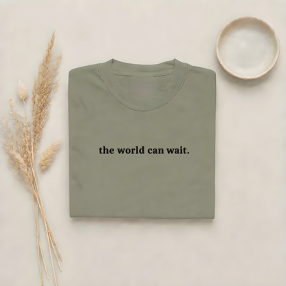 Moss garment-dyed Comfort Colors tee with "the world can wait" embroidered on the chest, Soft Rebellion