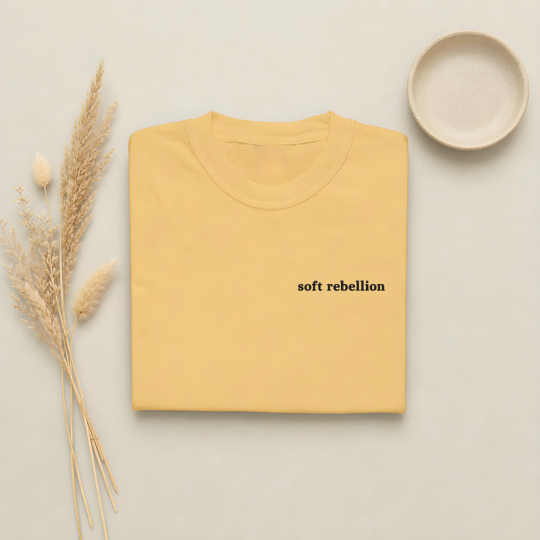 Mustard garment-dyed Comfort Colors tee with Soft Rebellion embroidered on the chest