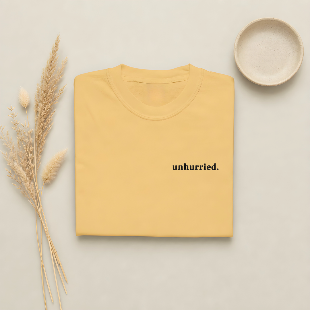 Mustard garment-dyed Comfort Colors tee with "unhurried" embroidered on the chest, Soft Rebellion