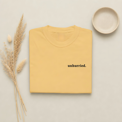 Mustard garment-dyed Comfort Colors tee with "unhurried" embroidered on the chest, Soft Rebellion