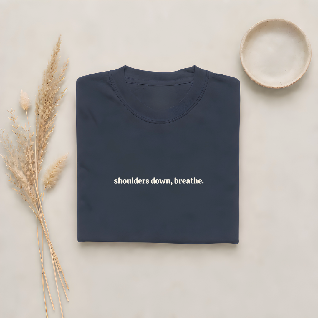 Navy garment-dyed Comfort Colors tee with "shoulders down, breathe" embroidered on the chest, Soft Rebellion
