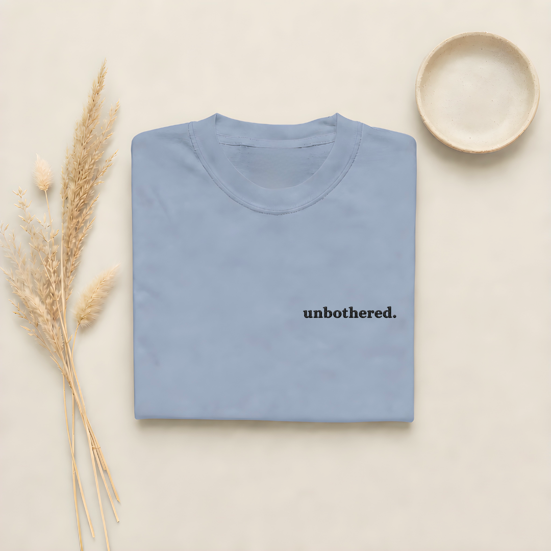 Blue Jean garment-dyed Comfort Colors tee with "unbothered" embroidered on the chest, Soft Rebellion