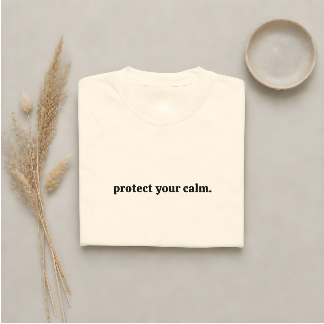 Ivory garment-dyed Comfort Colors tee with "protect your calm" embroidered on the chest, Soft Rebellion